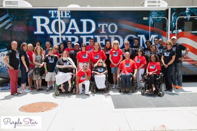 Disability advocates gather in front of the ADA Legacy Bus during its stop in Columbus on July 23.