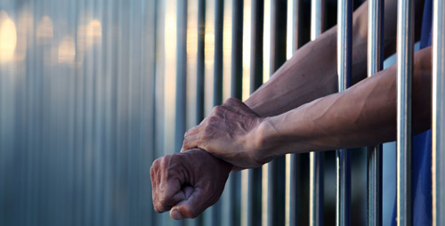 Arms through prison bars